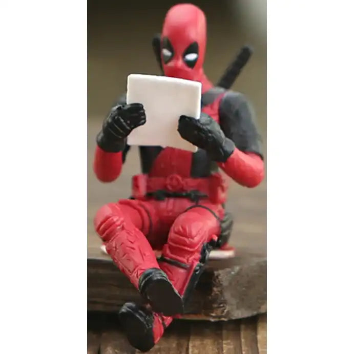 Deadpool sitting reading.