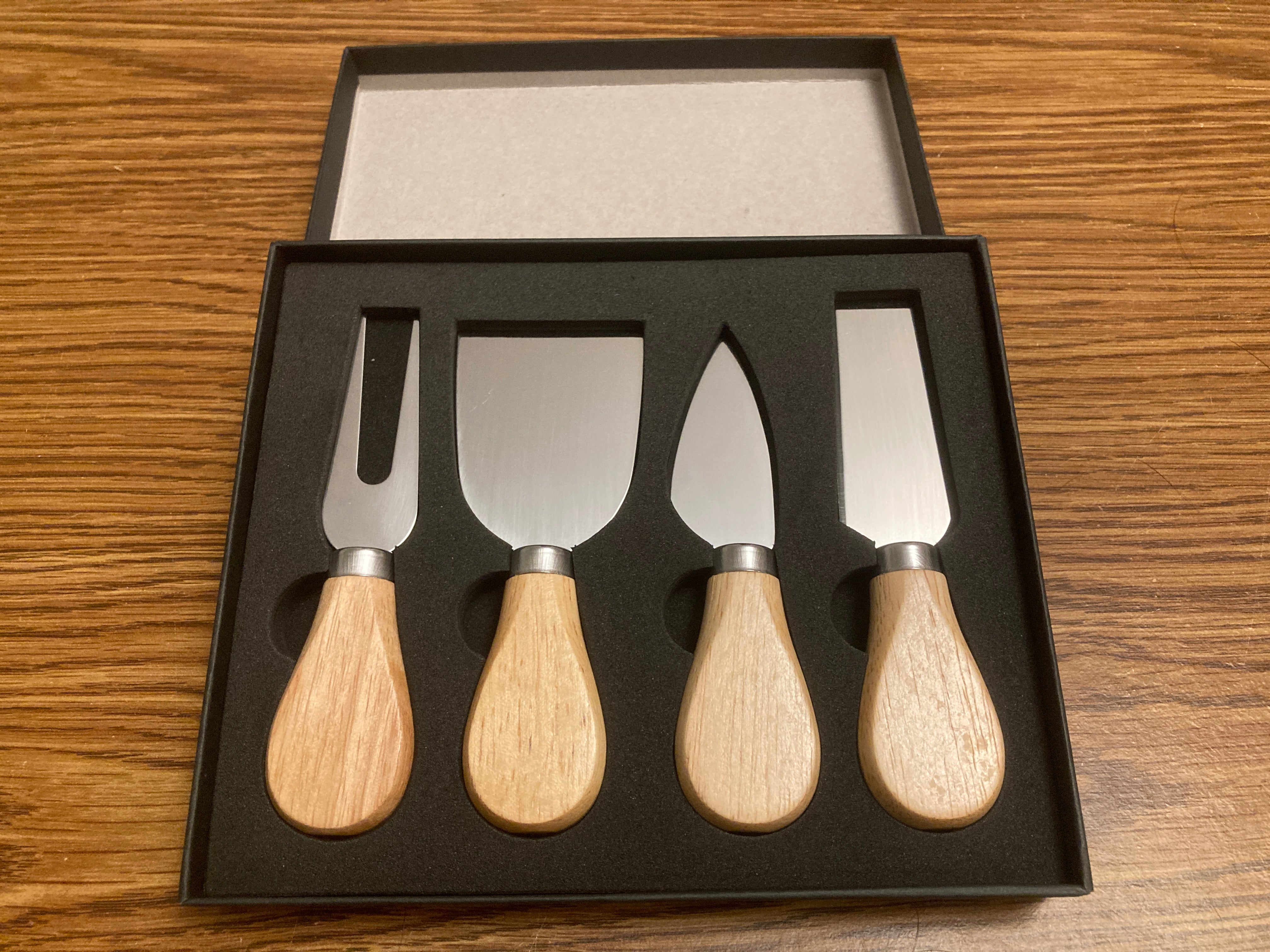 4-piece, stainless steel cheese knife-charcuterie gift set. This wooden handle cutlery gift set comes in it's own gift box.