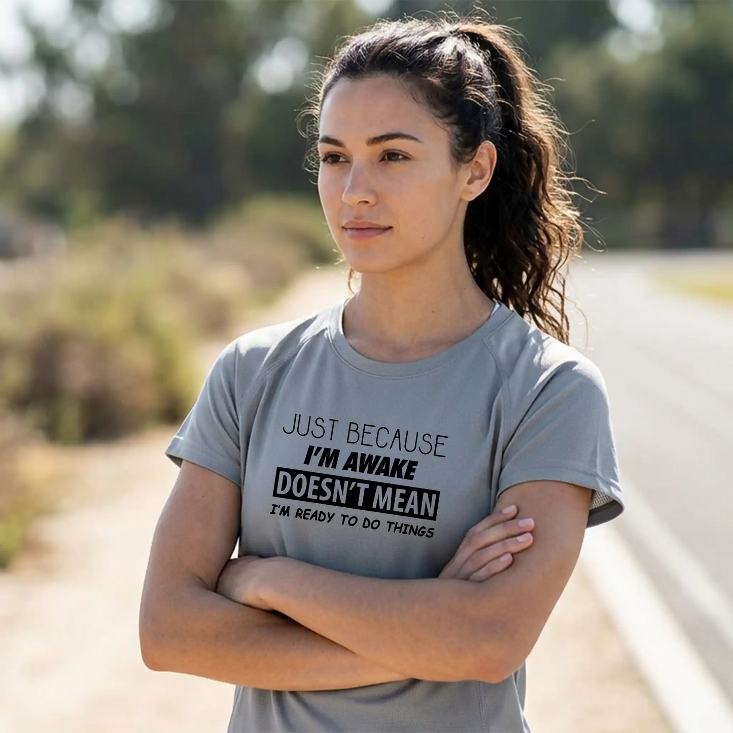 Female model wearing a short-sleeve Platinum performance tee with 'Just Because I'm Awake' humorous design - Keener Gifts apparel.