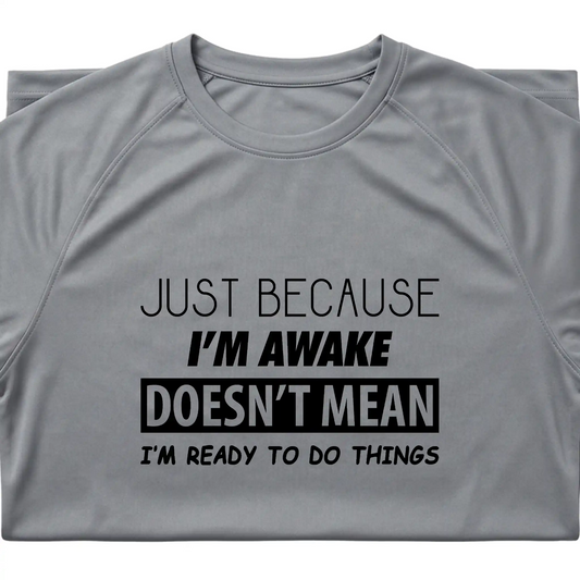 Close-up of 'Just Because I'm Awake Doesn't Mean I'm Ready To Do Things' graphic on a Platinum moisture-wicking performance shirt.