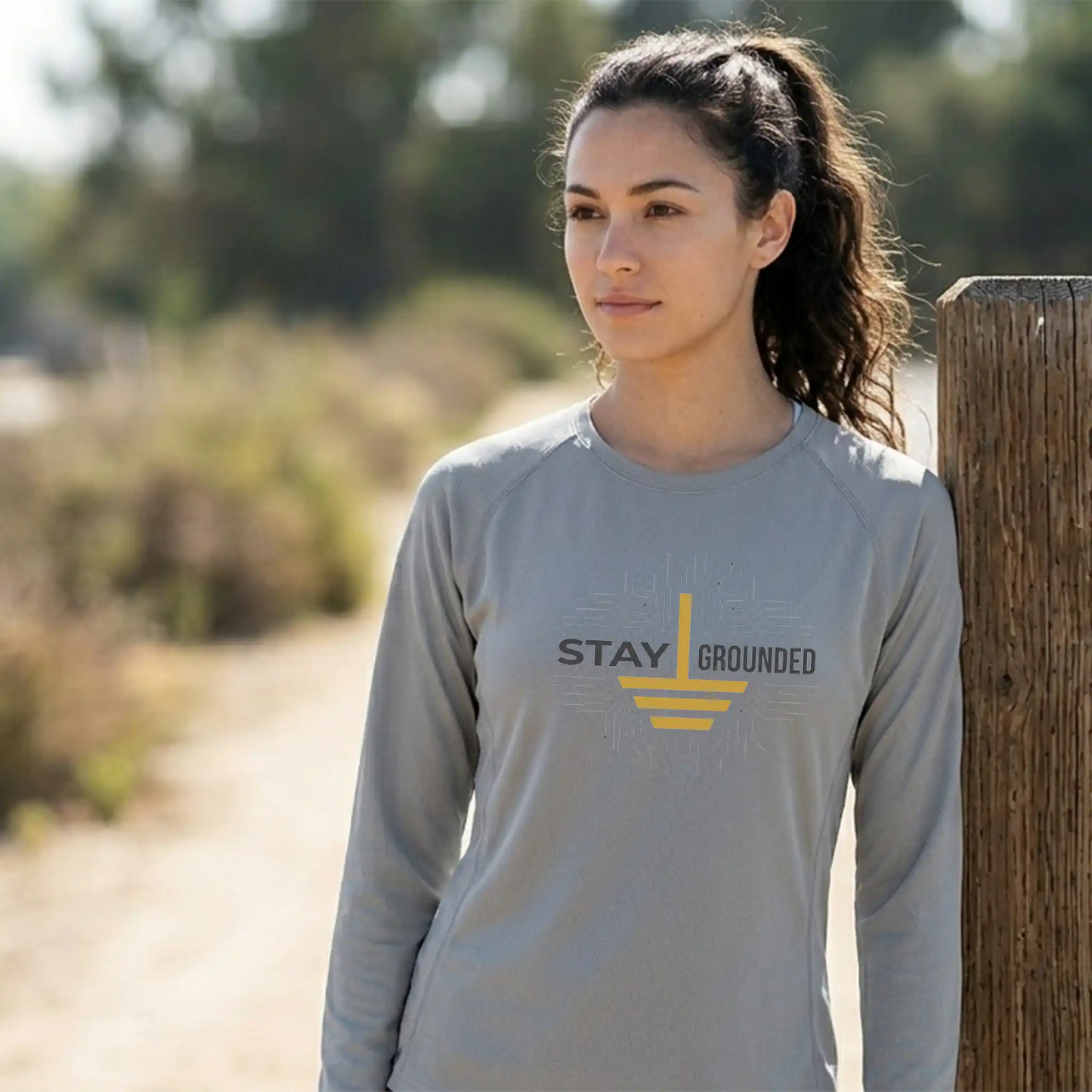 A female model wearing the long-sleeve Core365 CE10L moisture-wicking shirt in Platinum, showcasing the athletic fit and sun-protective coverage for outdoor training.