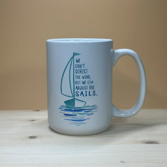 Nautical home decor 15oz ceramic coffee cup with motivational boating illustration on a pine wood stand.