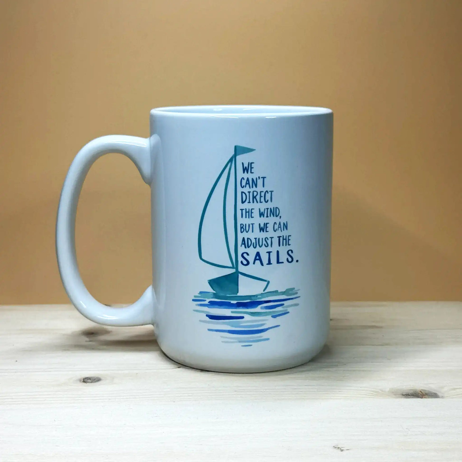 Inspirational sailing gift 15oz mu with blue sailboat vessel graphic and adjust the sails quote.